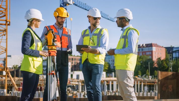 Diverse,Team,Of,Specialists,Use,Tablet,Computer,On,Construction,Site.